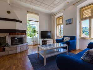 A living room with a fireplace, a television, a sofa, and a coffee table. - Petrinovic / HR-09466-01 by Interhome (Crikvenica)