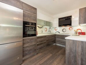 A modern kitchen with a built-in oven, a refrigerator, and a microwave. - Monique / HR-11121-01 by Interhome (Crikvenica)