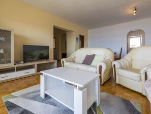 A living room with a sofa, TV, and a coffee table. - BUNETA 5 / HR-01926-07 by Interhome (Crikvenica)