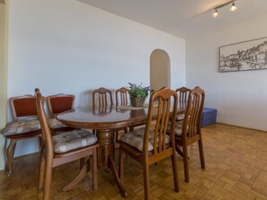 A dining area with a round wooden table and six chairs, a potted plant, and a wall-mounted painting. - BUNETA 5 / HR-01926-07 by Interhome (Crikvenica)