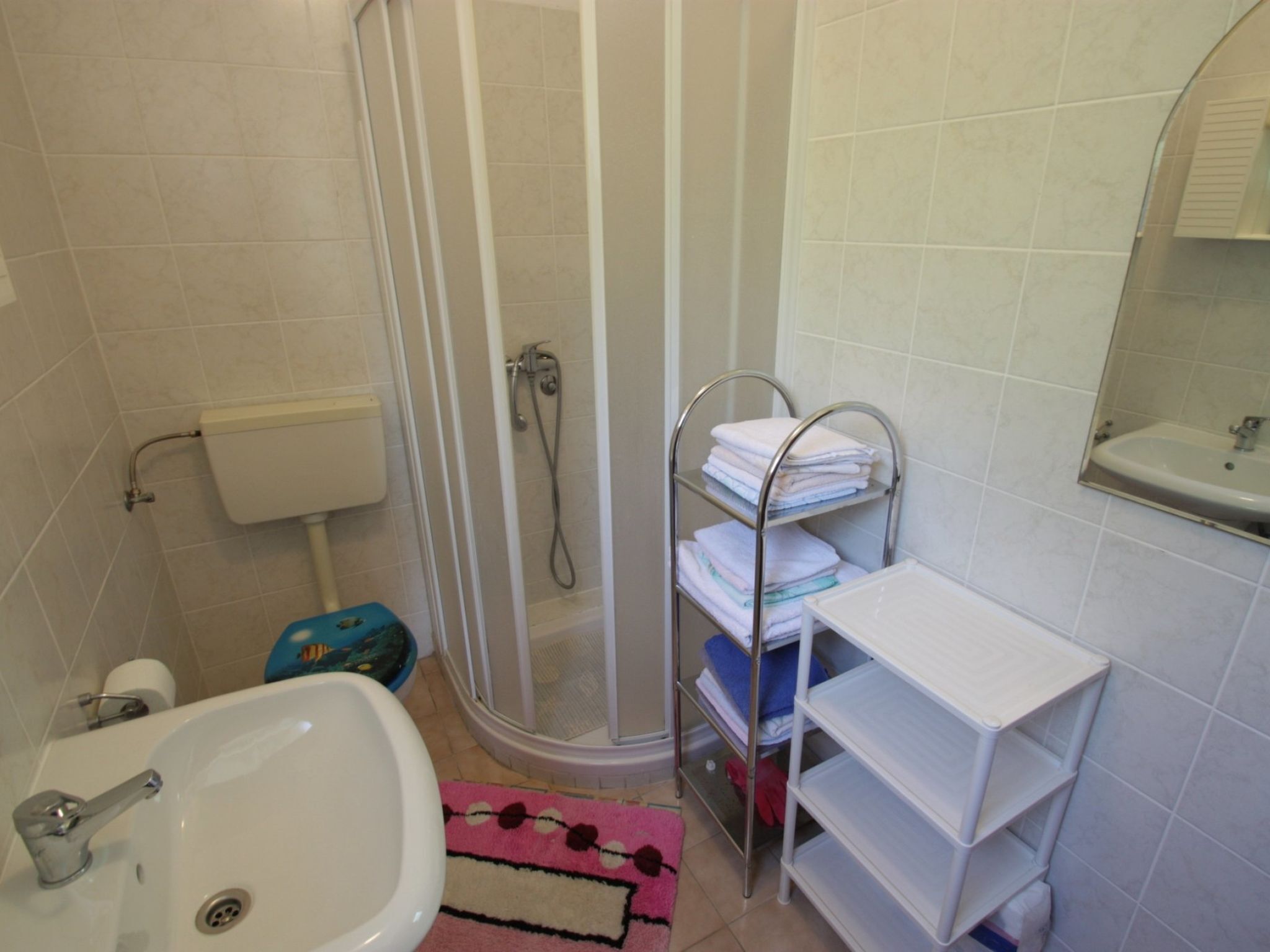 Ein Badezimmer mit Dusche, Waschbecken und Handtuchhalter.