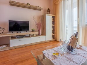 Un saló amb televisió de pantalla plana, armaris de fusta, una petita prestatgeria i una taula amb espelmes.
