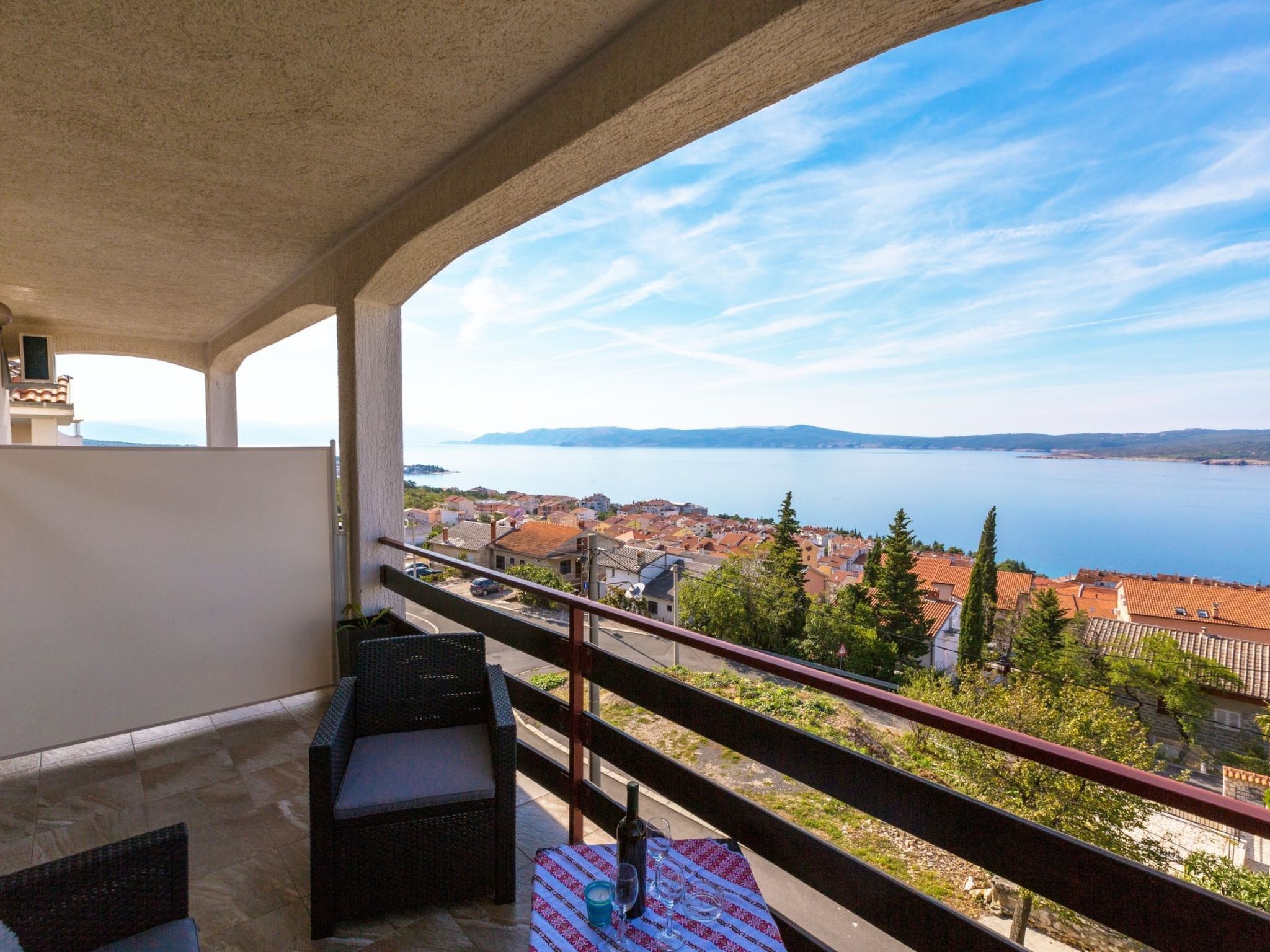 A balcony with a view of a lake and a town.