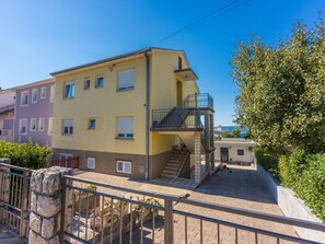 A multi-story building with a yellow facade, a balcony, and a staircase leading to an upper floor. - Sea View 1 prizemlje / HR-08682-05 by Interhome (Crikvenica)