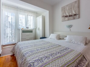 Ein Schlafzimmer mit einem Bett, einem Schminktisch, einem Spiegel und einem Bild an der Wand.