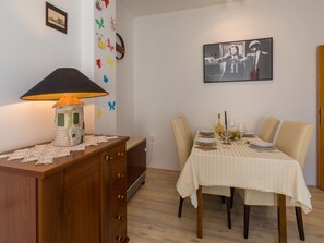 Ein Essbereich mit einem Tisch für zwei Personen, einer Lampe und einer Wand mit Schmetterlingsmotiven.
