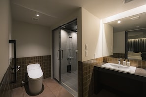 Et moderne badeværelse med toilet, bruser og vask.