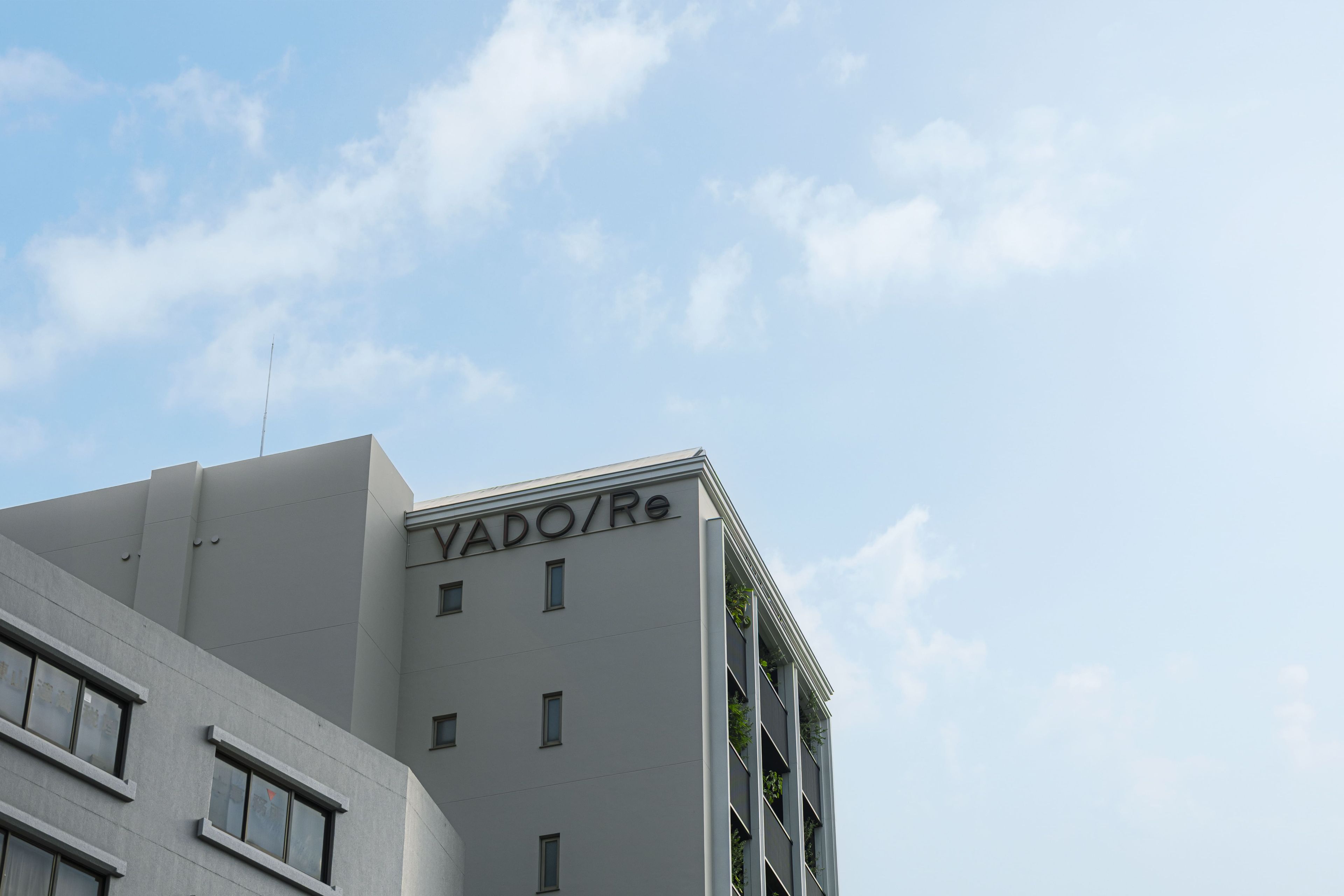 A building with a flat facade and a sign reading 'VADO/Re'.