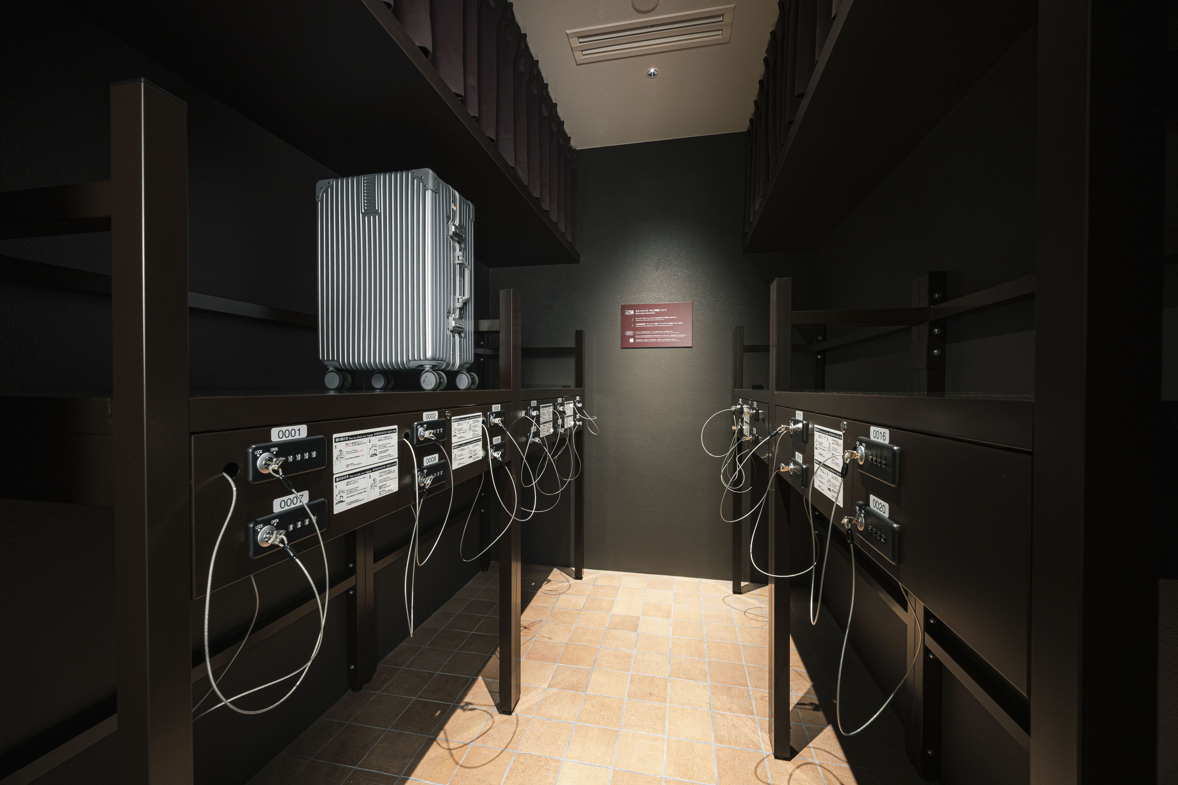 A hotel room with a minibar, a bed, and a bathroom with a shower.