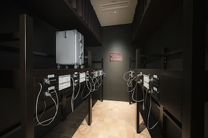 Una habitación de hotel con minibar, cama y baño con ducha.