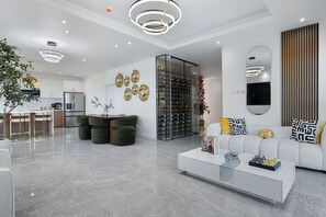 Un salon moderne avec un canapé blanc, une table basse et une table à manger avec un plateau en verre.