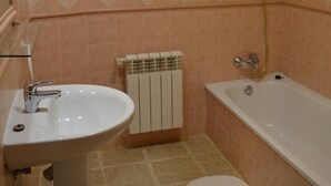 A bathroom with a sink, toilet, and bathtub. - Nuevo Hotel Capitolio (Valdepenas)