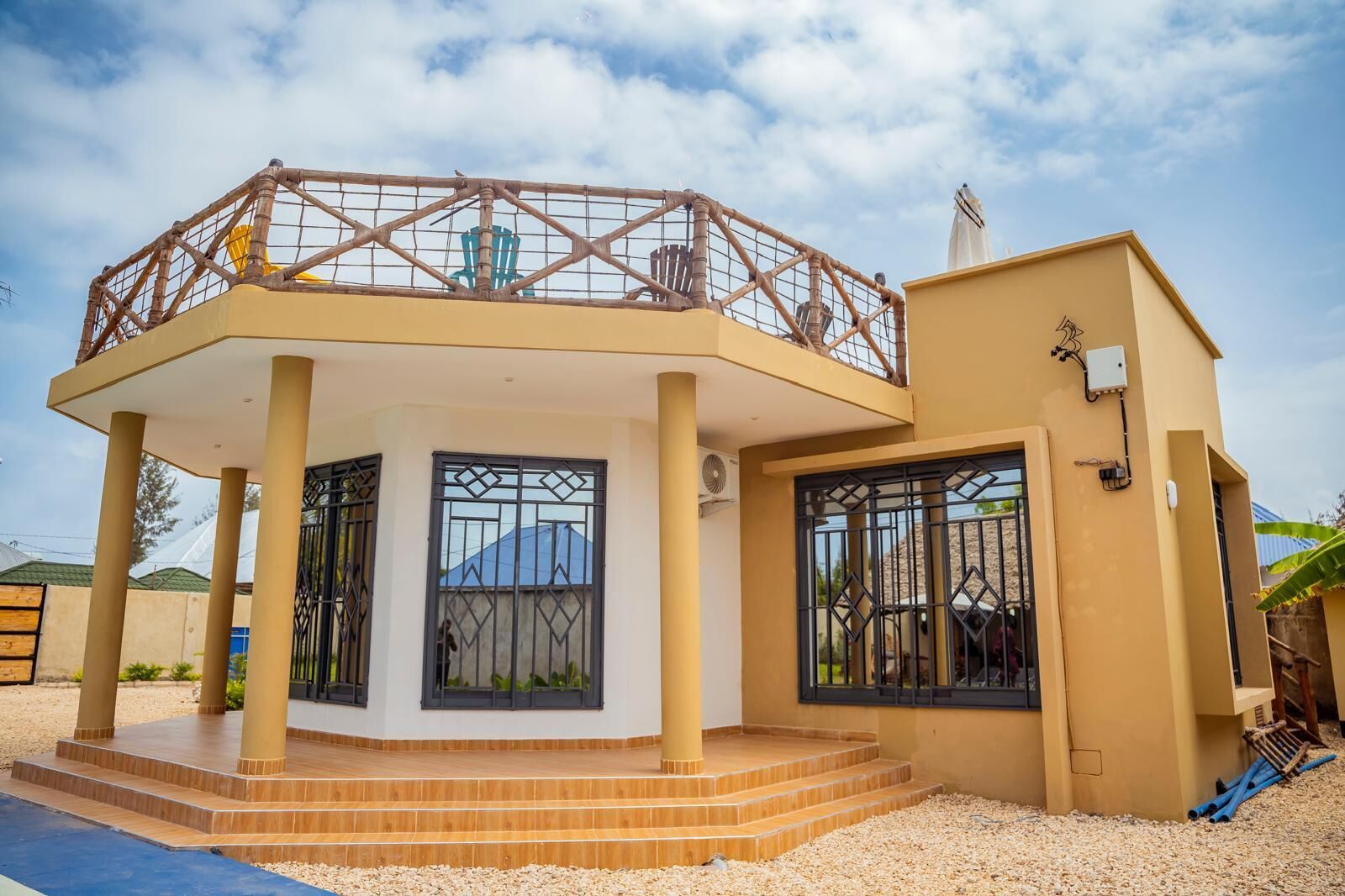 Une maison à deux étages avec un balcon, de grandes fenêtres et un petit espace piscine.