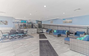 A spacious indoor area with a staircase, seating arrangements, and a view of the outside. - Atlantica 452 Oceanfront Escape (Myrtle Beach)
