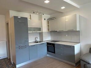 A modern kitchen with grey cabinets, a stainless steel refrigerator, a built-in oven, and a dishwasher. - Teen Apartment • Spectacular views • 3CH • Free parking (Ilidža)