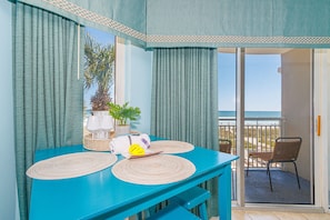 A room with a blue table, two woven placemats, a white vase, and a potted plant. - Oceanfront 1BR Retreat for 4! Atlantica 200 (Myrtle Beach)