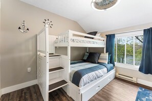 A bunk bed with a desk and drawers, a window with curtains, and a view of greenery outside. - Blue Canoe: Cozy Fall Lakefront Escape (East Stroudsburg)