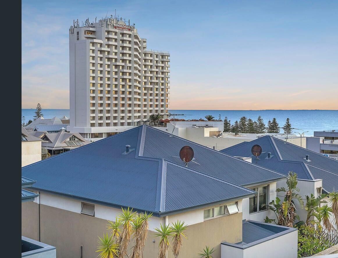 Een hotel met modern design, met een opvallend gebouw, een balkon en uitzicht op zee.