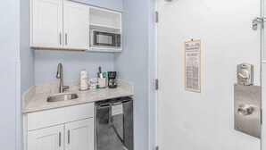 A compact kitchenette with a microwave, sink, and dishwasher. - Boardwalk 440 Studio (Myrtle Beach)