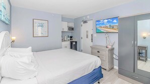 A bedroom with a bed, a desk, a chair, a television, and a wardrobe. - Boardwalk 440 Studio (Myrtle Beach)
