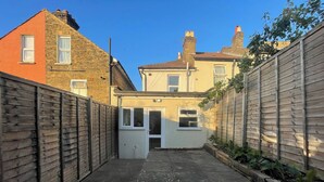 A narrow alleyway with a wooden fence on one side and a building on the other. - Full House - Croydon Centre (Croydon)