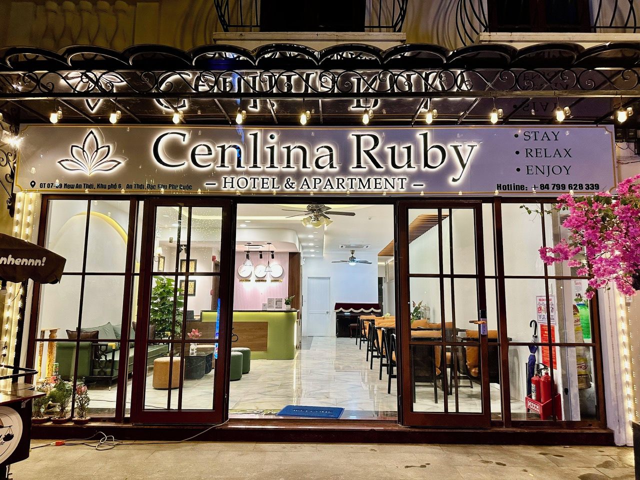 The exterior of the Cenlina Ruby Hotel & Apartment with a reception area visible through the glass doors.
