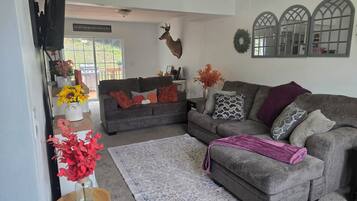A living room with a grey sofa, a wooden coffee table, and a decorative deer head.