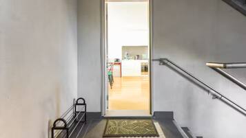 A staircase leading to a bright room with a kitchen in the background.