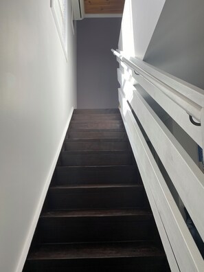 A staircase with dark wooden steps and white railings, leading to a higher floor. - Coastal Retreat 400 Metres to Beach (Cowes)