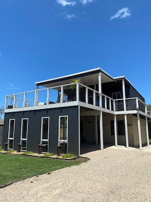 A modern two-story building with a balcony, large windows, and a gravel driveway. - Coastal Retreat 400 Metres to Beach (Cowes)