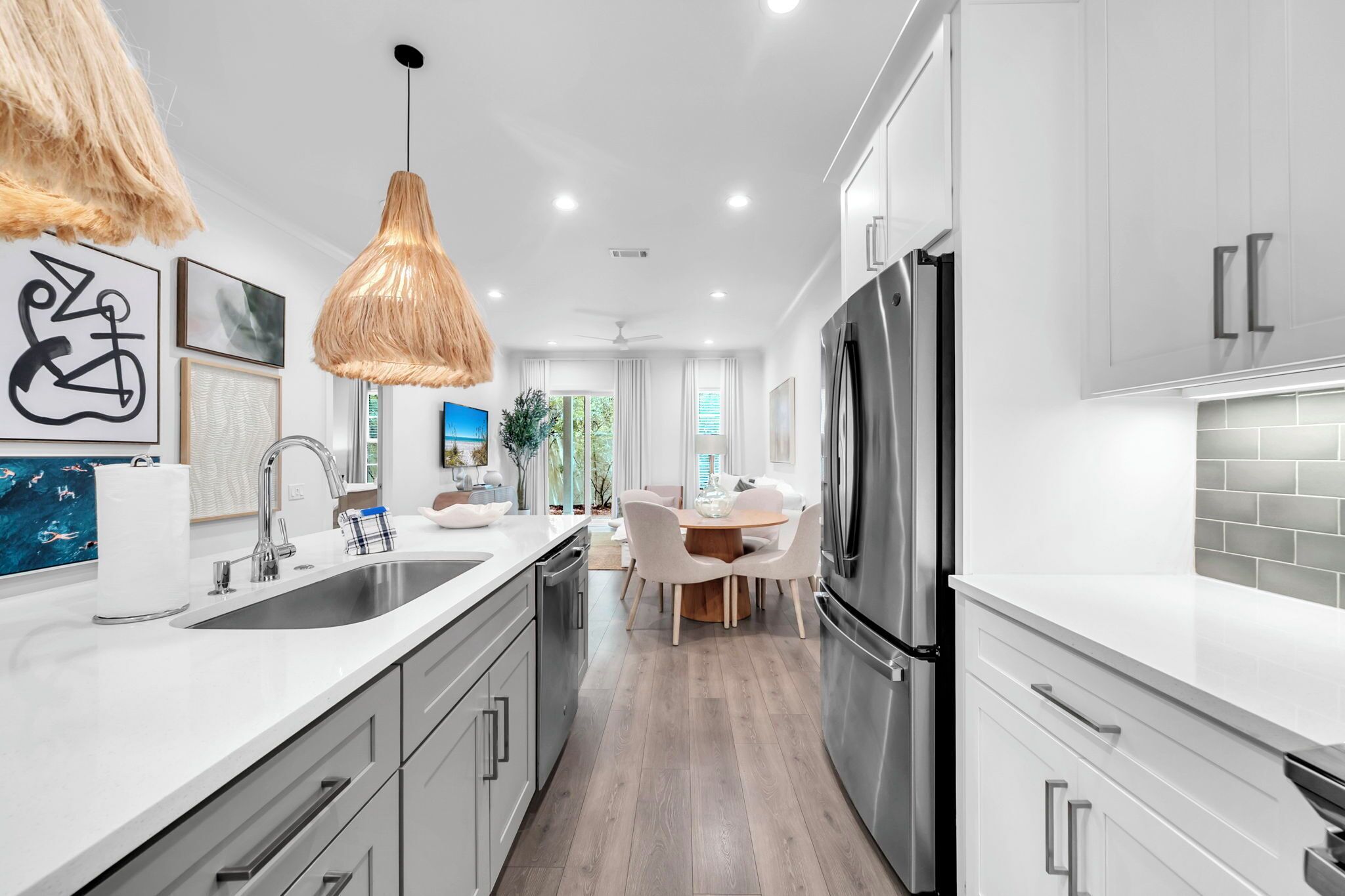 A modern kitchen with stainless steel appliances, white cabinetry, and a central island.