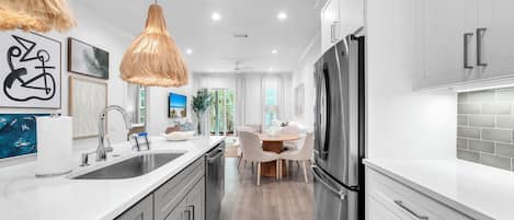 A modern kitchen with stainless steel appliances, white cabinetry, and a central island.