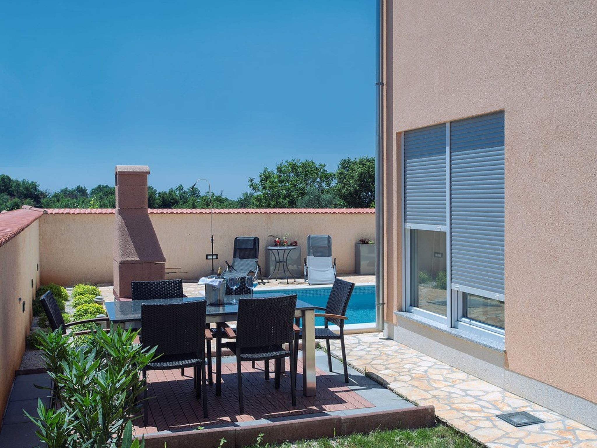 A patio with a pool, outdoor furniture, and a barbecue grill.