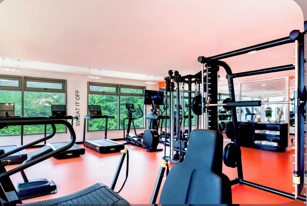 A gym with treadmills, elliptical machines, and weightlifting equipment.