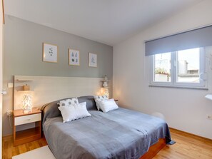 A bedroom with a bed, bedside tables, a window, and wall art. - Villa Delia by Interhome (Medulin)
