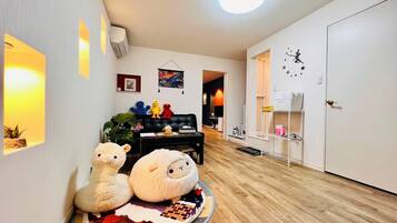 A living room with a sofa, a round rug, and a door with a star decal.