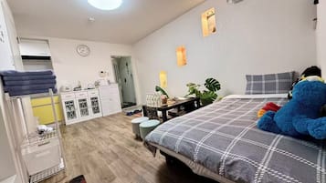 Una camera da letto con un letto, una scrivania, un armadio e un bagno visibile sullo sfondo.