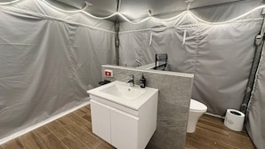 Ein Badezimmer mit einem weißen Waschbecken, Spiegel und WC.
