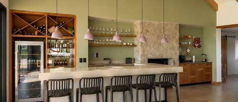 Una cocina amplia con techo alto, vigas de madera y una isla central con taburetes de bar.