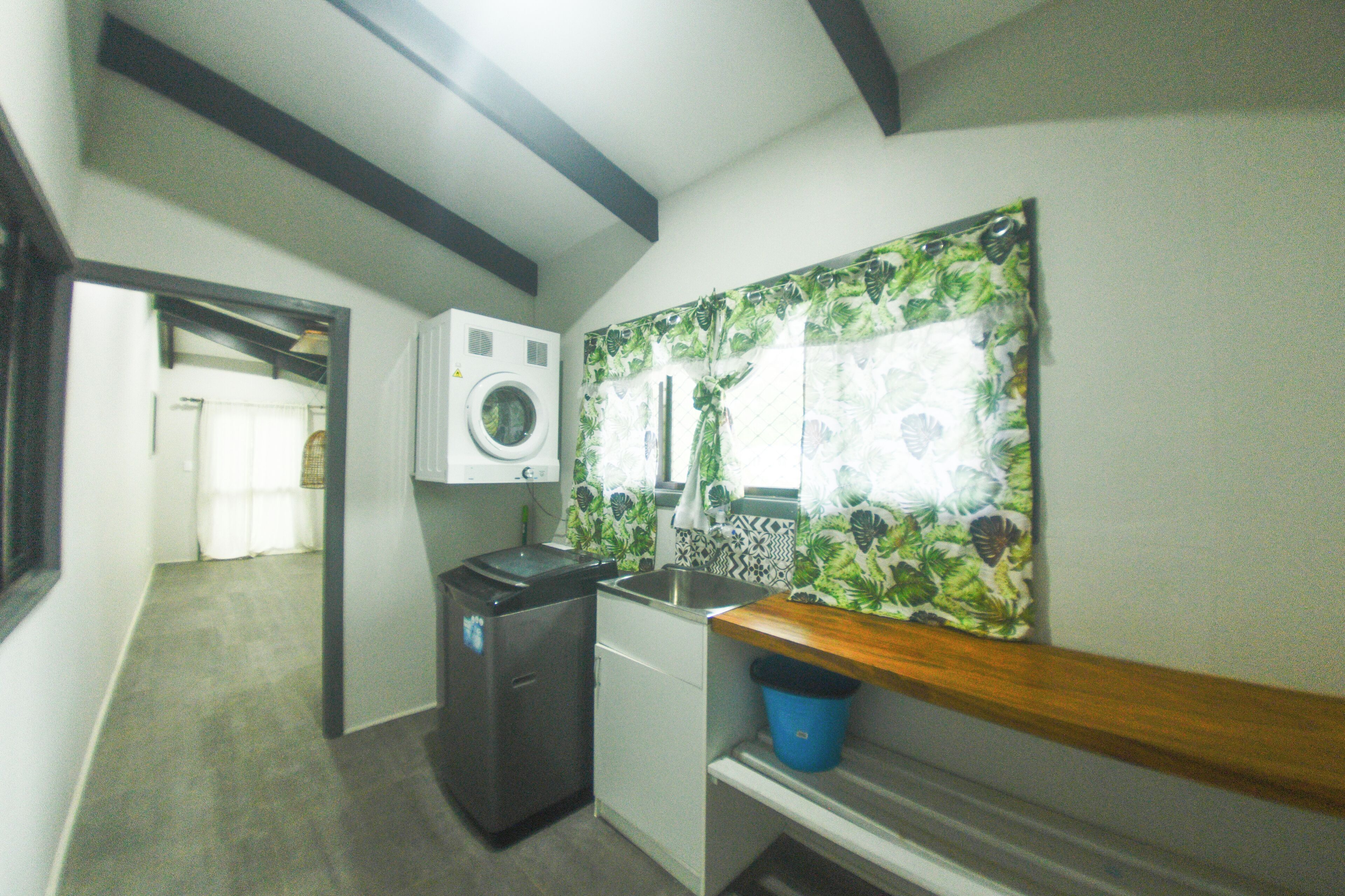 A compact kitchen with a washing machine, a sink, and a small refrigerator.