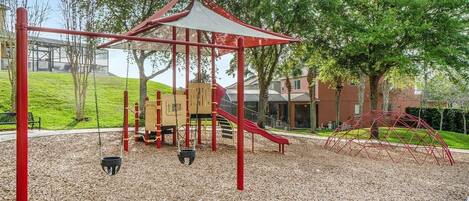 A playground with swings, a slide, and a climbing structure.