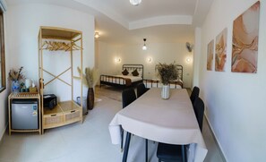 Une pièce comprenant un lit, une table à manger et un coin cuisine.