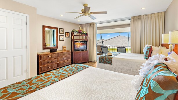 A hotel room with two beds, a ceiling fan, a TV, a dresser, and a balcony with a view. - Kaanapali Condo - 1BR/2BA - Beach Cabana, Pools, Private Lanai, A/C (Lahaina)