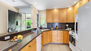 A modern kitchen with wooden cabinets, a built-in oven, and a stainless steel sink. - Kaanapali Condo - 1BR/2BA - Beach Cabana, Pools, Private Lanai, A/C (Lahaina)
