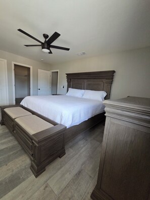 A bedroom with a bed, a bench, a ceiling fan, and a wardrobe. - Fabulous 3-bedroom house with AC in charming Roswell (Roswell)