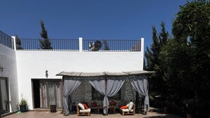 A swimming pool with a covered seating area and a white building in the background. - Villa Sylvester, Essaouira (Essaouira)