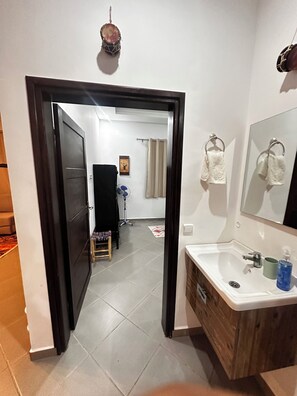 A bathroom with a sink, mirror, and towel rack. - Villa Sylvester, Essaouira (Essaouira)