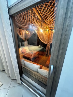 A room with a bed, a wooden bench, and a window with curtains. - Villa Sylvester, Essaouira (Essaouira)