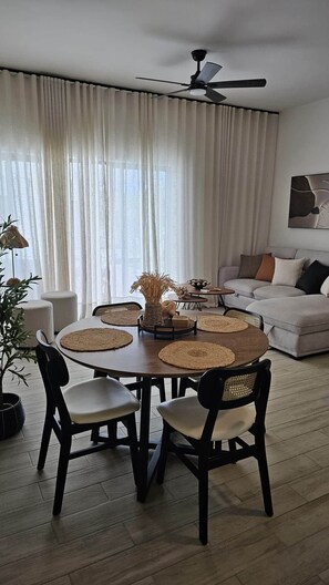 Un coin repas avec une table ronde, des chaises et un ventilateur de plafond.
