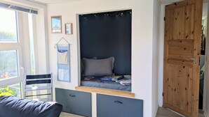 Ett rum med en inbyggd säng, ett litet skrivbord och en garderob.